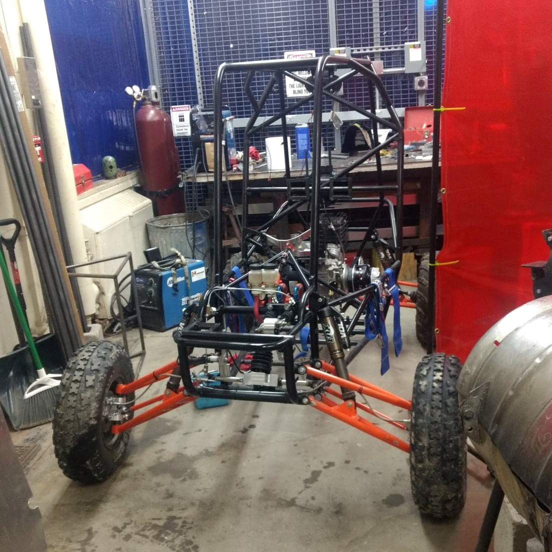 The frame of a Baja SAE car sitting in the shop.